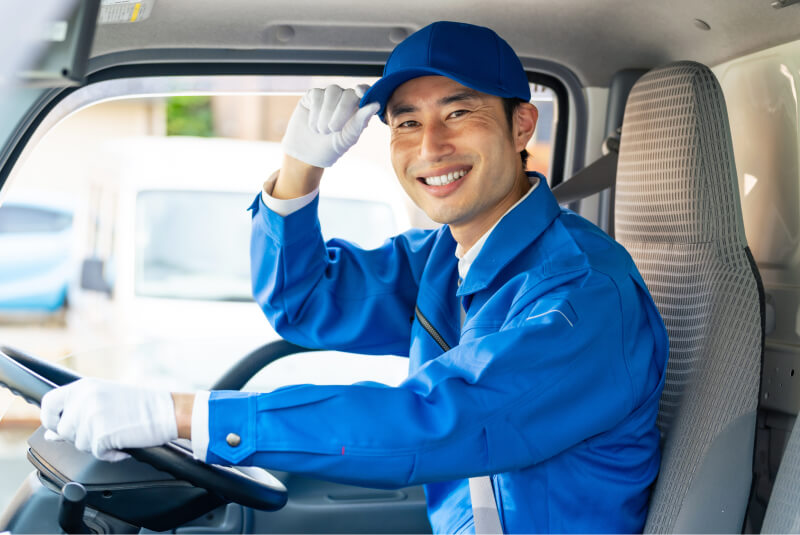 車に乗っている配送業者の男性